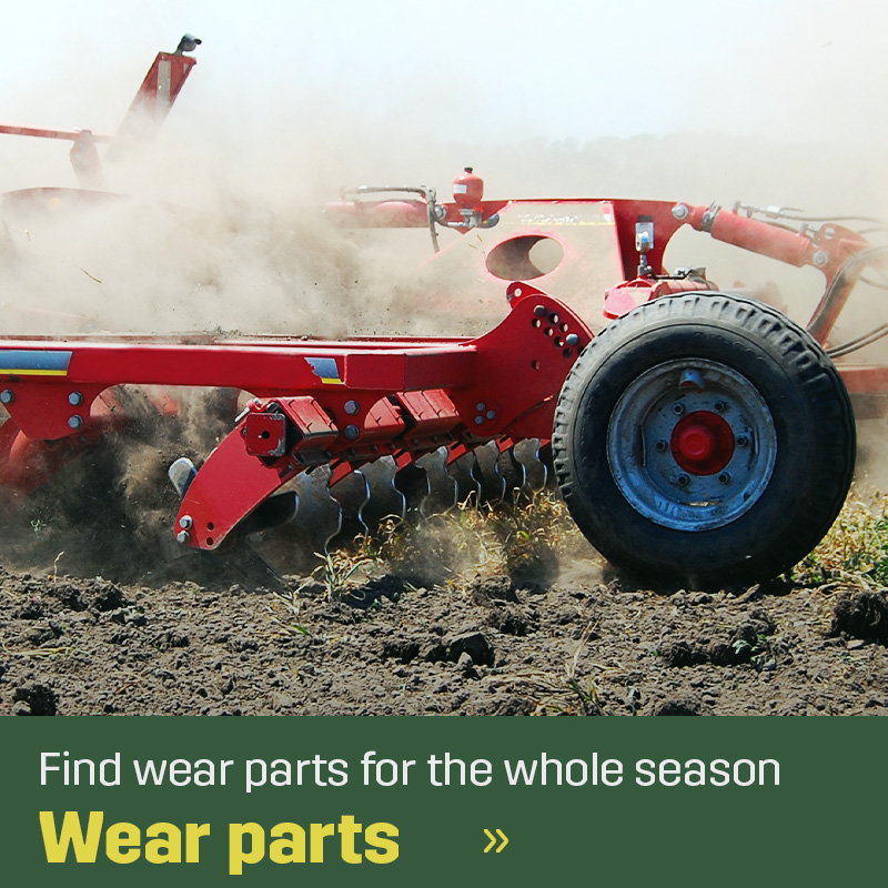 Tillage implement working in the field, turning soil with visible dust and rotating parts. Sagros wear parts are used in equipment for soil preparation before sowing and cultivation.